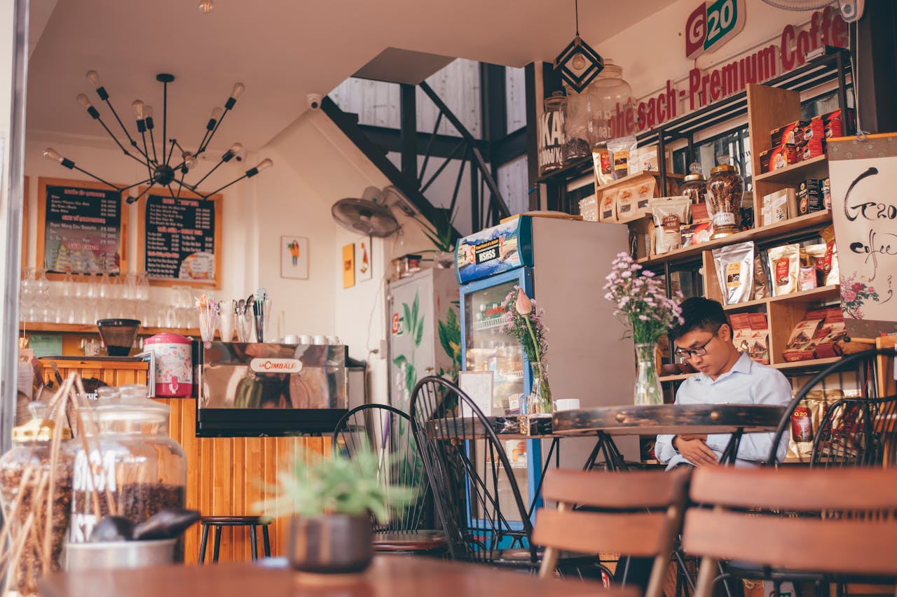 services-02 Charming coffee shop interior with a man seated, showcasing modern design in Đắk Lắk, Vietnam.